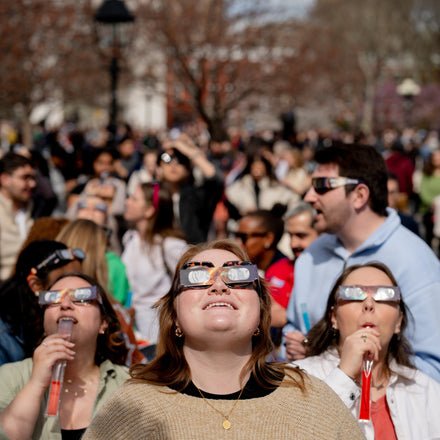 People wearing solar eclipse glasses