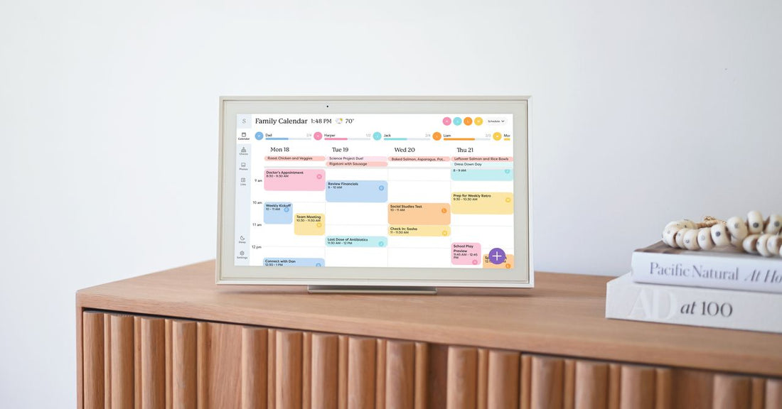 A family gathered around a touchscreen calendar