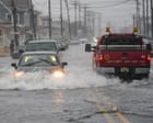 Coastal road in North Carolina flooded after the nor'easter, showing stranded cars and high water levels.