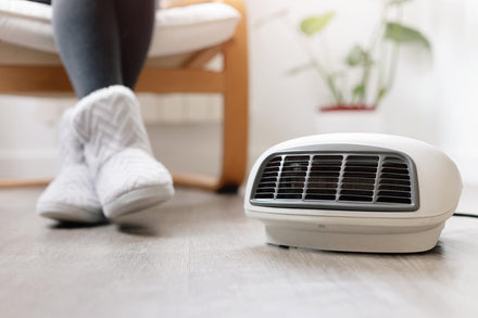 Close‑up of a space heater with its cord plugged into an outlet, highlighting potential heat buildup.