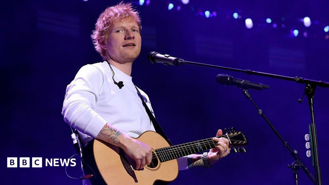 Ed Sheeran on stage at the Philadelphia concert, microphone in hand, addressing the audience.