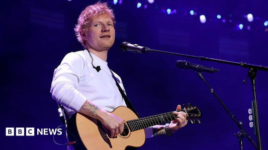 Ed Sheeran on stage at the Philadelphia concert, microphone in hand, addressing the audience.