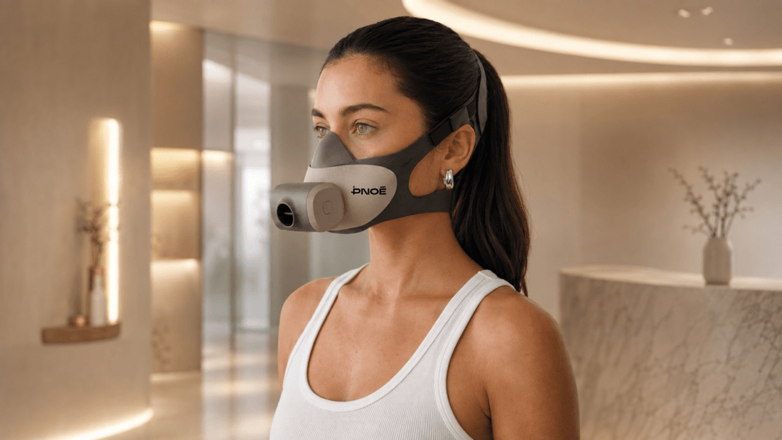 Close‑up of PNOĒ breath‑analyzing mask with sleek design placed on a gym bench