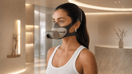 Close‑up of PNOĒ breath‑analyzing mask with sleek design placed on a gym bench