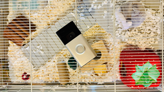 A repurposed smart doorbell mounted on a hallway wall, showing its camera lens aimed at an interior space.