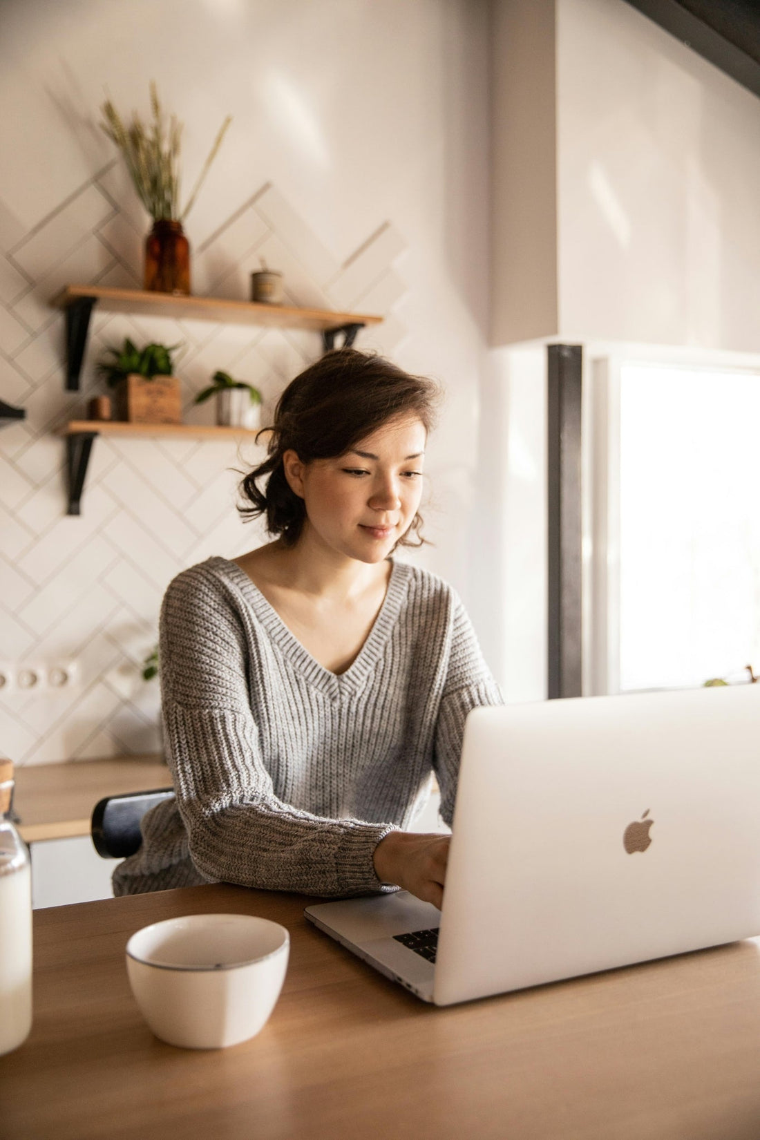 Digital entrepreneur working on a laptop in a cozy home setting.