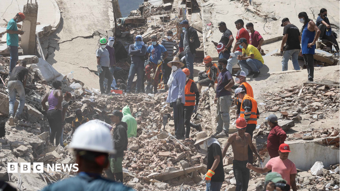 People searching for survivors in rubble
