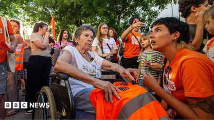 Crowd of protesters holding signs demanding housing rights in a Spanish city square