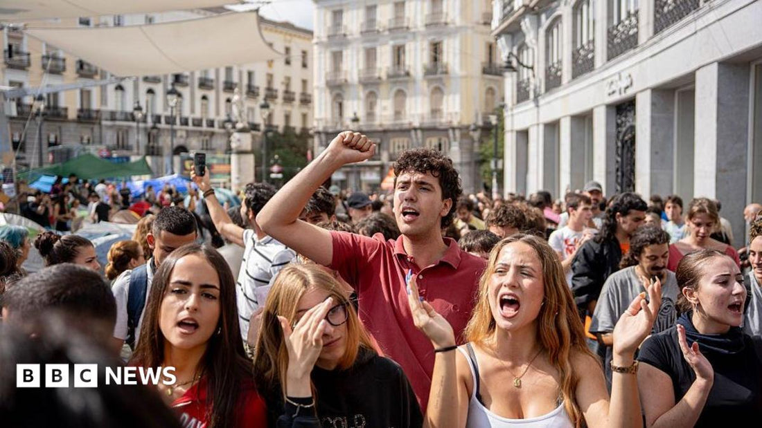 Protesters holding signs outside a Madrid apartment building demanding an end to evictions after an elderly woman's removal.