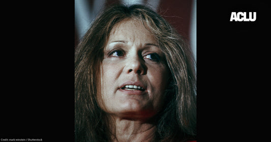 Gloria Steinem speaking at a 1970s women's rights rally, emphasizing legal action.