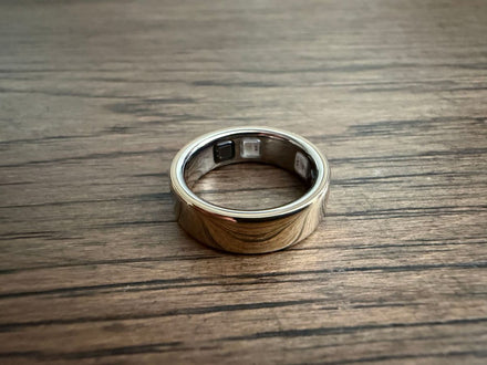 Close-up of an Oura health ring on a wrist, highlighting its sleek design and sensor placement