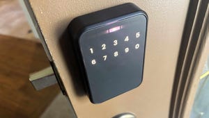 A person holding a smartphone with a smart lock app open