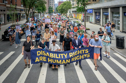 Protesters holding signs outside a federal building demanding disability integration protections
