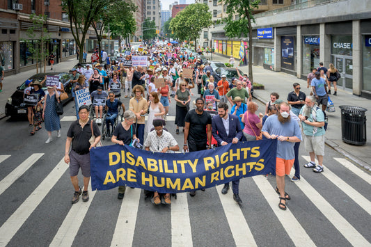 Protesters holding signs outside a federal building demanding disability integration protections