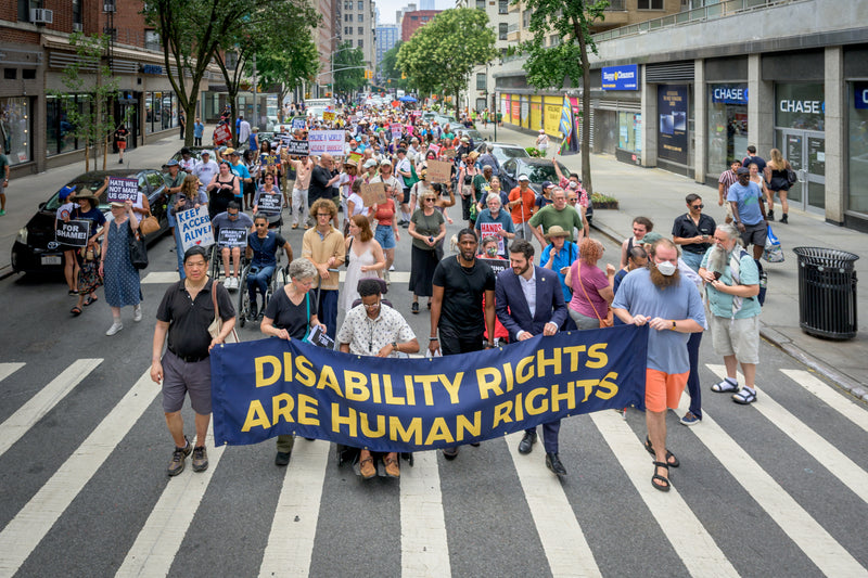 Protesters holding signs outside a federal building demanding disability integration protections