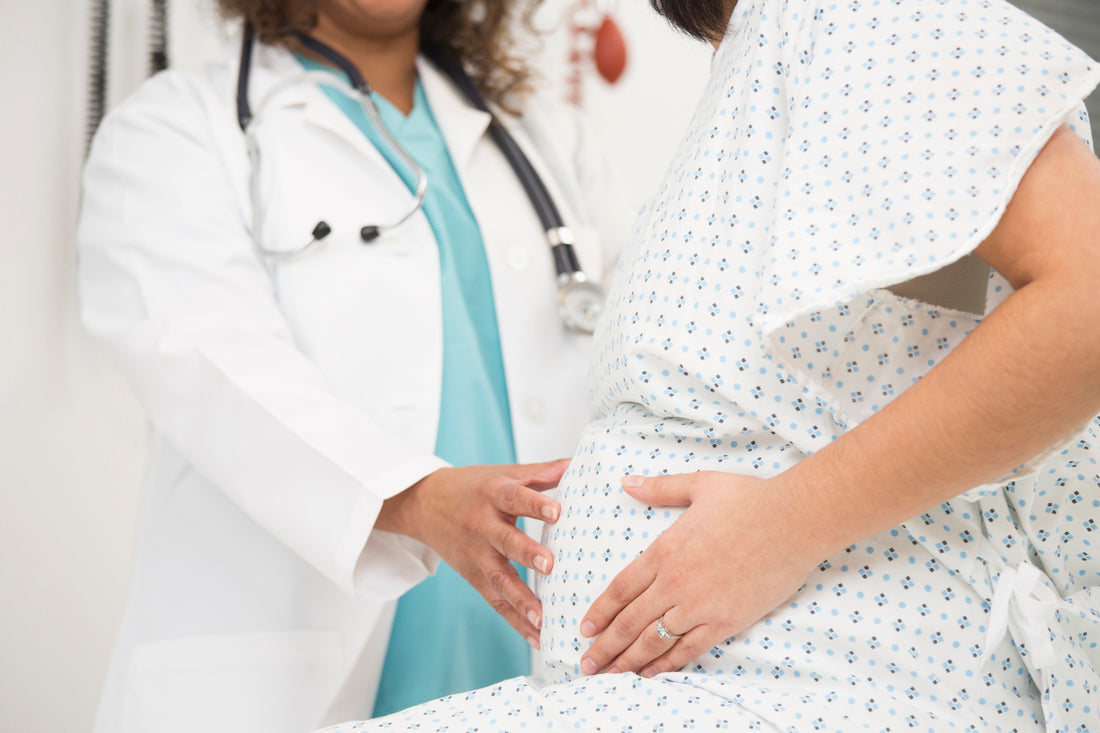 A pregnant woman holding a baby block with a dollar sign on it