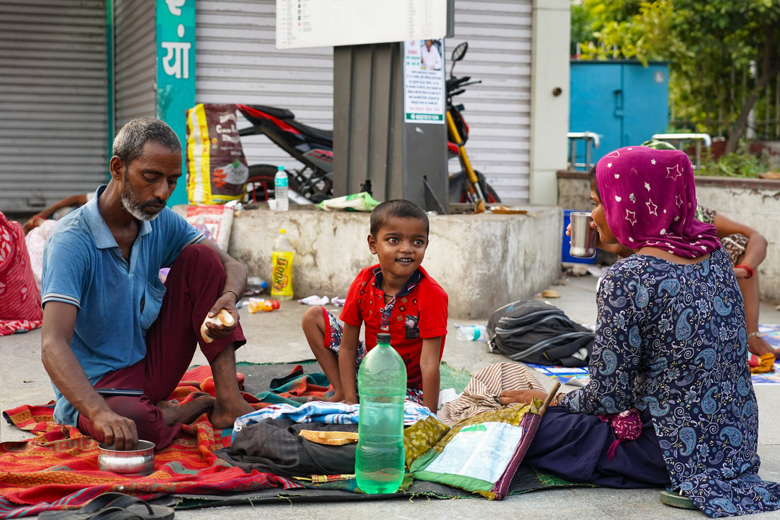 Family members sleeping on a hospital sidewalk in Delhi under a night sky