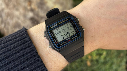 Close‑up of Casio F‑B100W smartwatch showing retro black case with blue accent highlights
